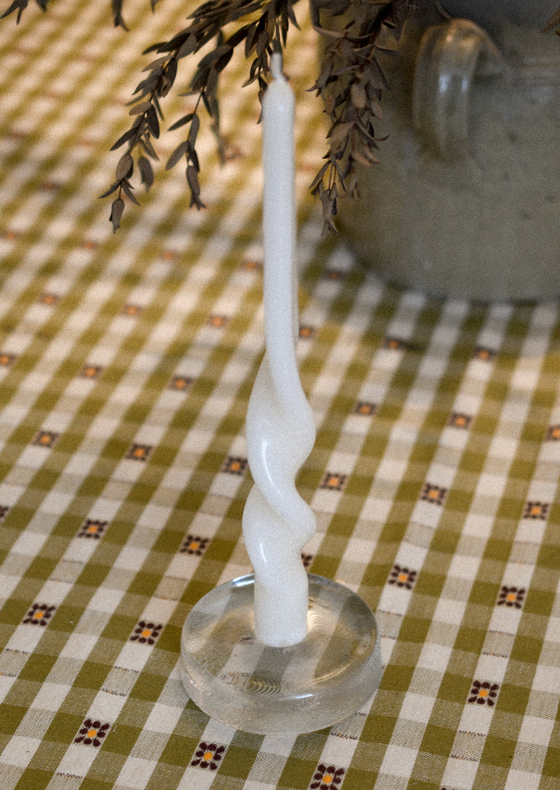 A spiral shaped taper candle with high gloss finish in white.