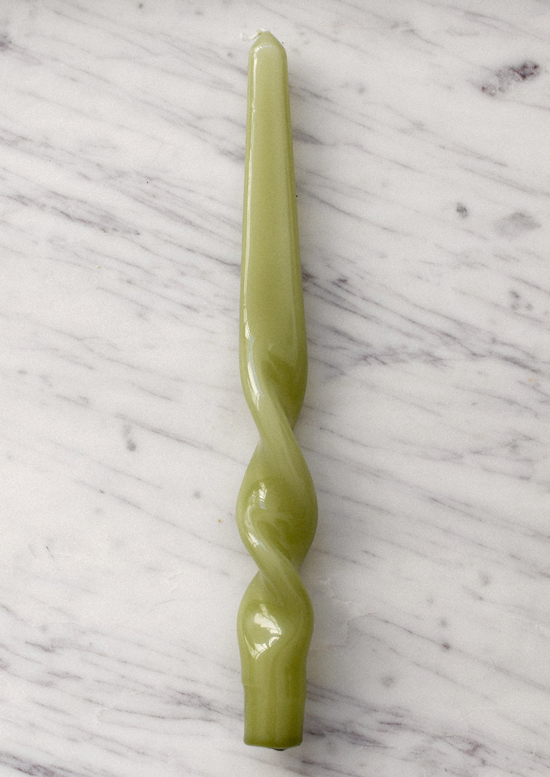 A spiral shaped taper candle with high gloss finish in meadow green.